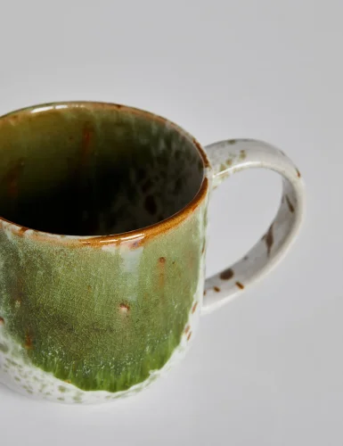 Green and brown spotted pottery mug