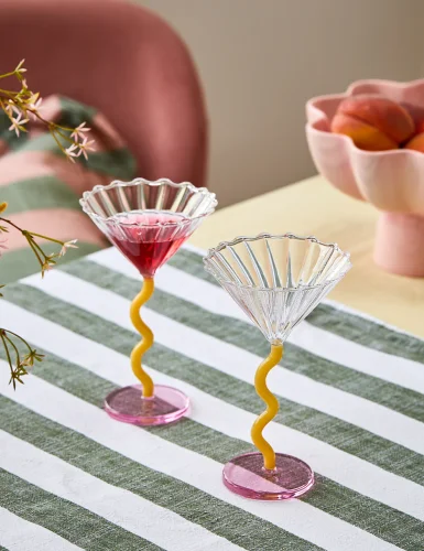 2 martini glasses filled with pale purple and yellow curly hair
